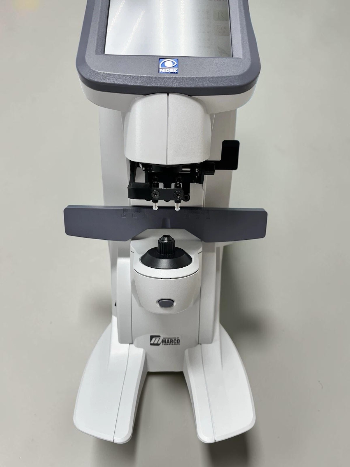 Nidek LM-7 - Auto Lensmeter - Used 4 Nidek LM-7 auto lensmeter used — lens table, marking mechanism and eyepiece front view